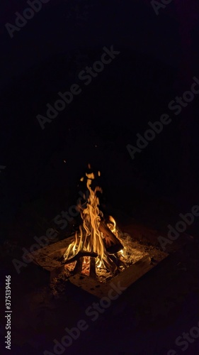 Obraz na płótnie Заголовок: Camp fire in the night. Bonfire. Flame and fire sparks on dark background. Black copy space.
w salonie
