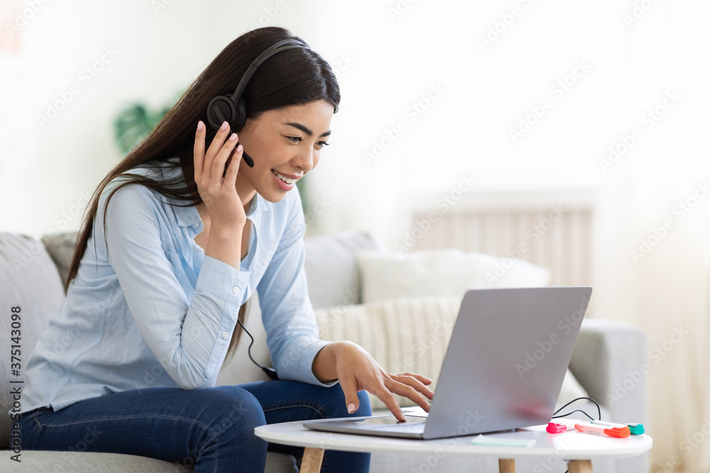 Asian Girl Studying Foreign Languages Online With Laptop And Headset At Home Asian Girl Studying Foreign Languages Online With Laptop And Headset At Home