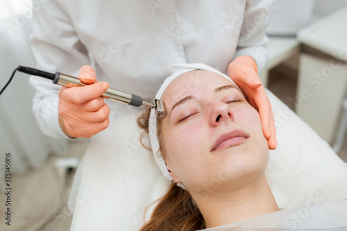 A professional cosmetologist performs a Thermolifting procedure at the spa. Beautiful caucasian woman on a cosmetic procedure. health Center