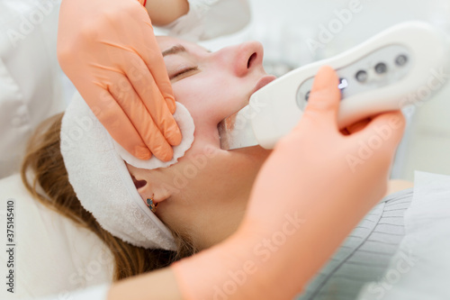 A professional beautician performs a mechanical facial cleansing procedure at the spa. Beautiful caucasian woman on a cosmetic procedure. health Center