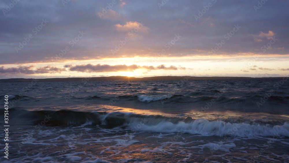 breaking waves with the setting sun