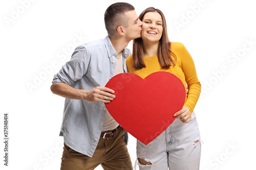 Young man kissing a female and holding a red heart