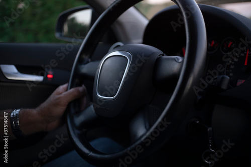 A man drives an elegant car holding the steering wheel