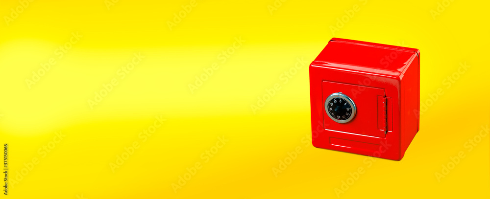 Red moneybox (piggy bank) made as safe. on yellow - obrazy, fototapety, plakaty 