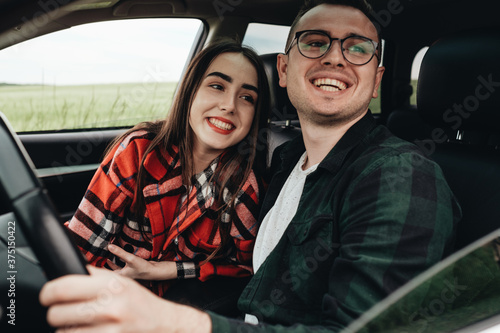 Young Beautiful Couple Sitting in the Car and Enjoying the Roadtrip