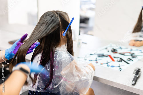 Fotografia little girl dyes her hair purple in a hairdressing salon