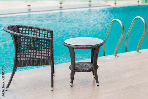 Chairs and Table with a part of swimming pool. © shine