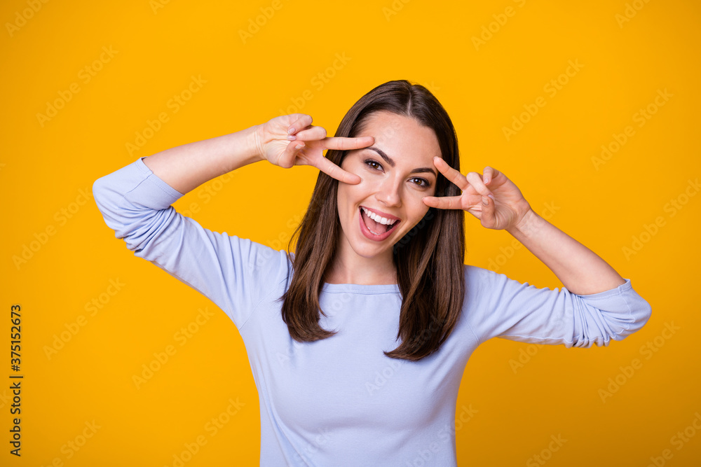 Photo of positive crazy charming youth girl make v-sign enjoy rest relax wear good look clothes isolated over vibrant color background Photo of positive crazy charming youth girl make v-sign enjoy rest relax wear good look clothes isolated over vibrant color background
