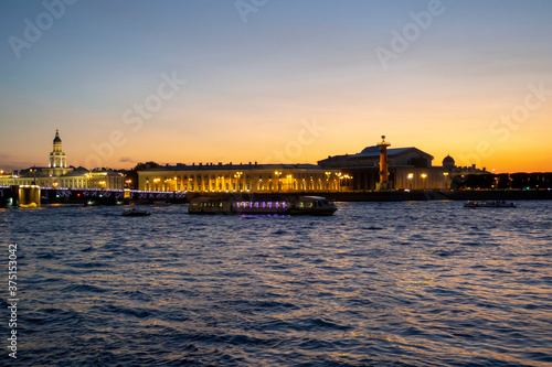 panoramic view from the river to the evening city, reflection of illumination in the water © Zh.anna