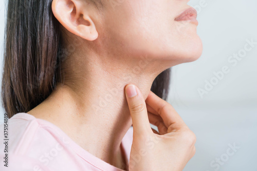 Woman with hands holding her Throat in pain.Health-care Concept.Selective focus