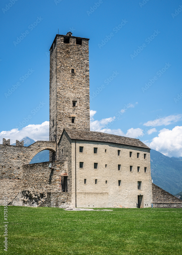 Scenic vertical view of Castelgrande castle white tower and wall with clear blue sky during summer in Bellinzona Switzerland