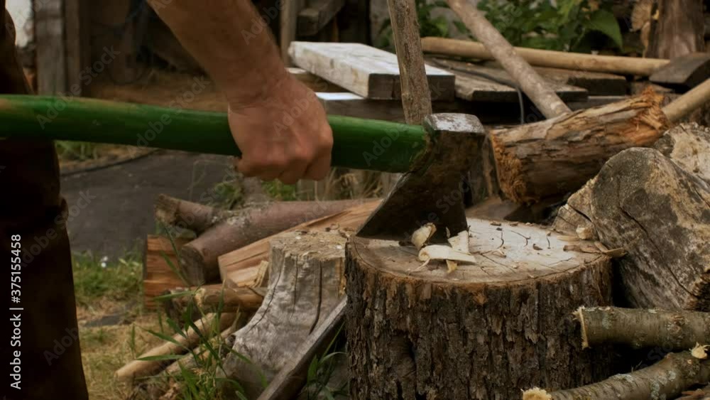 A rural man cuts wood with an axe and makes a peg for construction. Slow motion A rural man cuts wood with an axe and makes a peg for construction. Slow motion