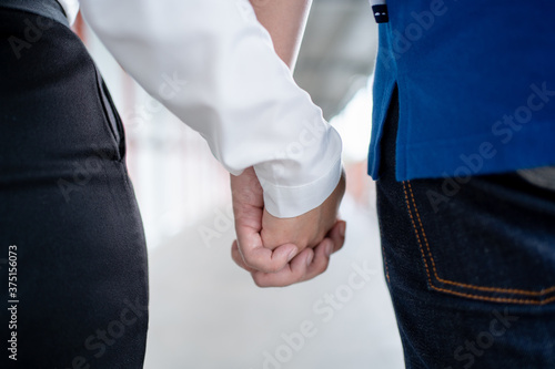 Close-ups of a happy gay couple holding hands. Concept of homosexuality and same-sex marriage.