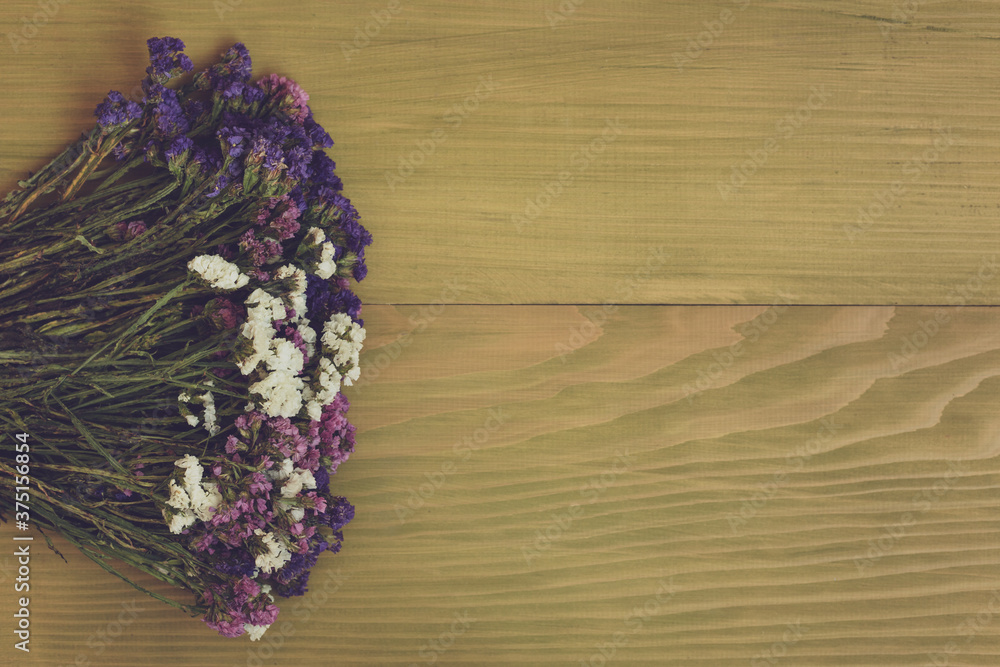 Image of beautiful dried flowers on wooden background.