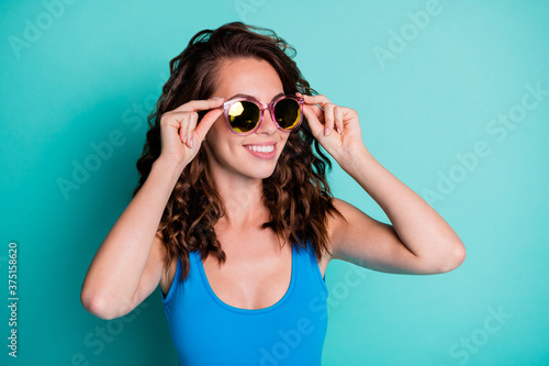 Close-up portrait of her she nice-looking attractive pretty cheerful cheery wavy-haired girl wearing touching specs resting resort abroad isolated on bright vivid shine vibrant blue color background