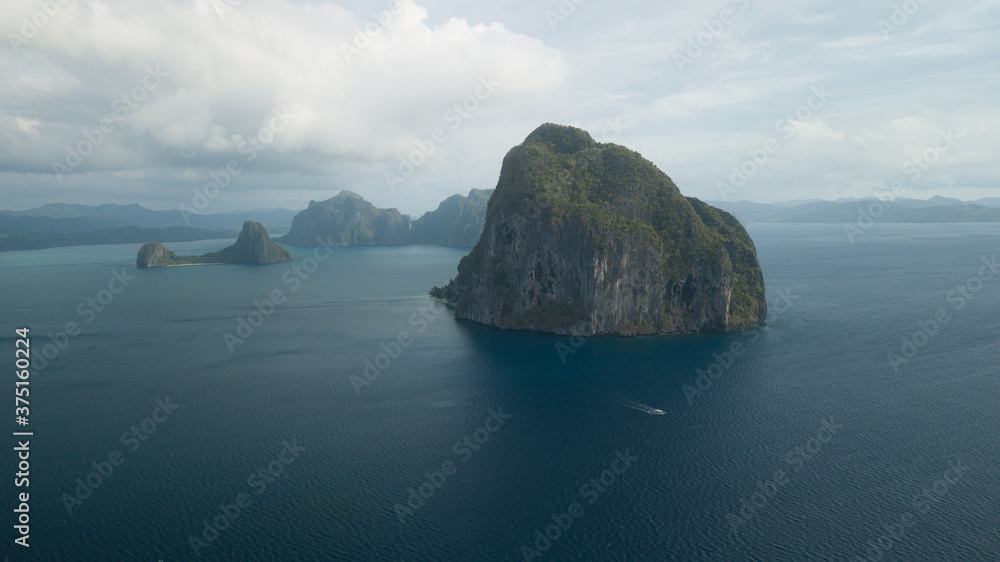 Fototapeta premium Aerial view of some island and a ship sailing in Philippines