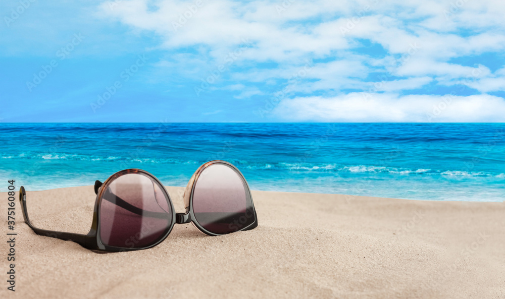 Sunglasses on the seashore,tropical beach vacation background .