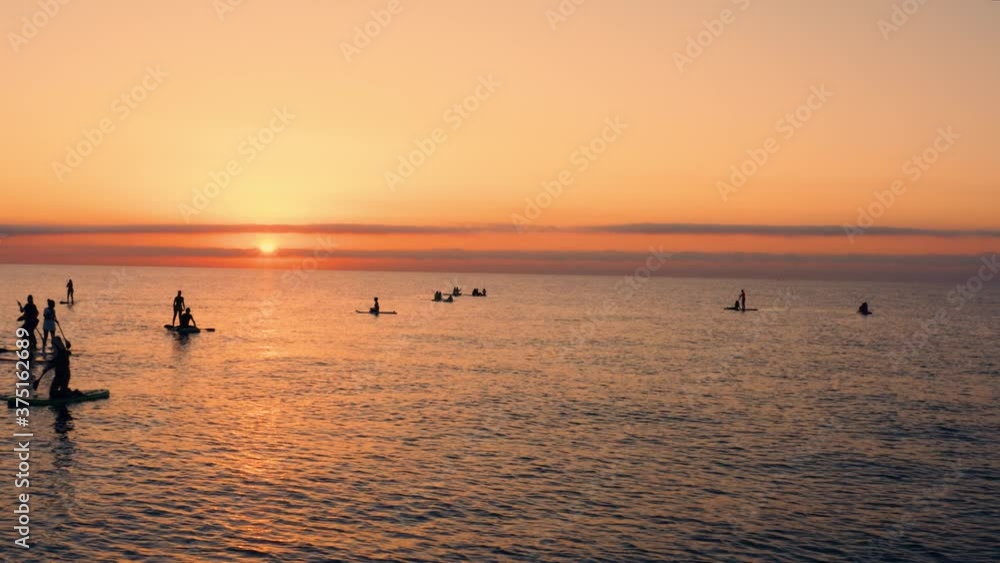 Silhouette di persone che fanno Stand up Paddle o sup, un sport che si svolge su una tavola da surf alzati all'alba sul Mare. Silhouette di persone che fanno Stand up Paddle o sup, un sport che si svolge su una tavola da surf alzati all'alba sul Mare.