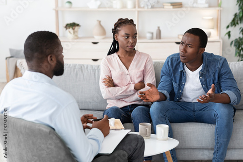 Marriage Therapy Session. Black couple speaking to family counselor about relationship problems © Prostock-studio