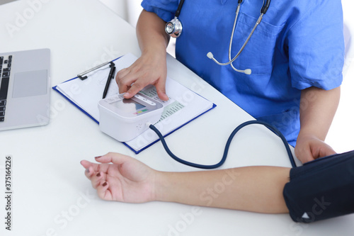 Doctor checking old woman patient arterial blood pressure. Health care