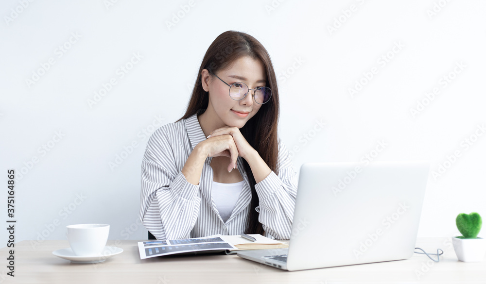 Young Asian woman works on paperwork in her own home online. Young Asian woman works on paperwork in her own home online.