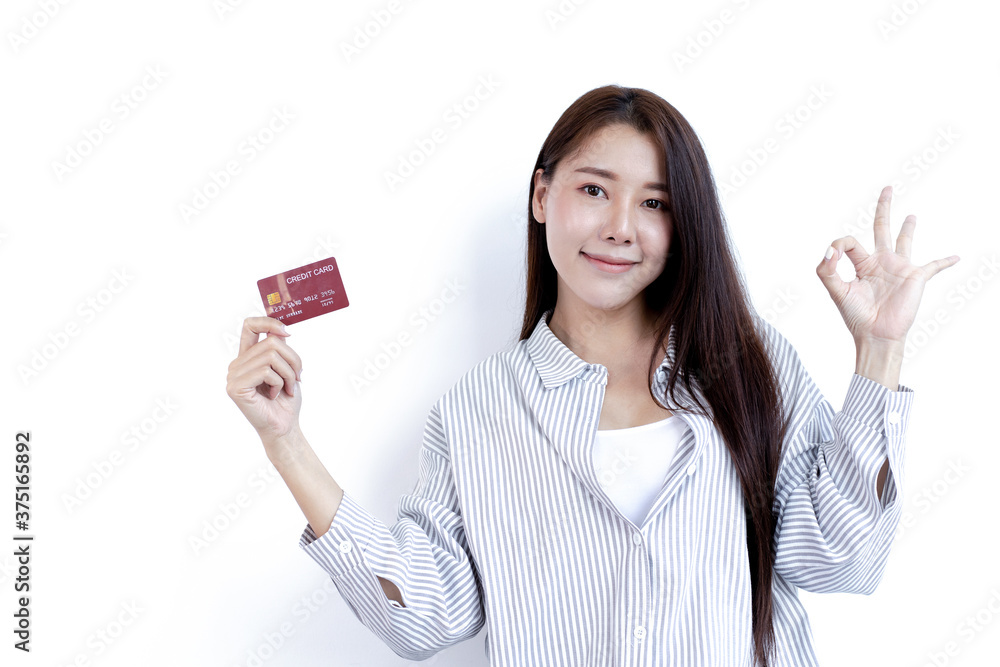 Young Asian woman holding a credit card and smiling happily. Young Asian woman holding a credit card and smiling happily.
