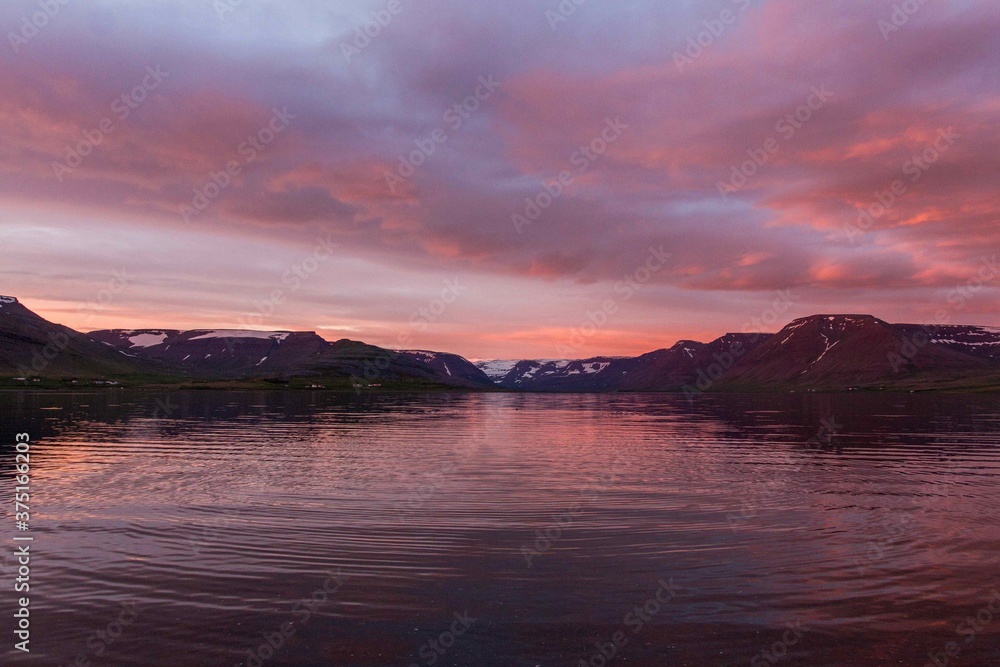Pink sunset over a lake with mountains