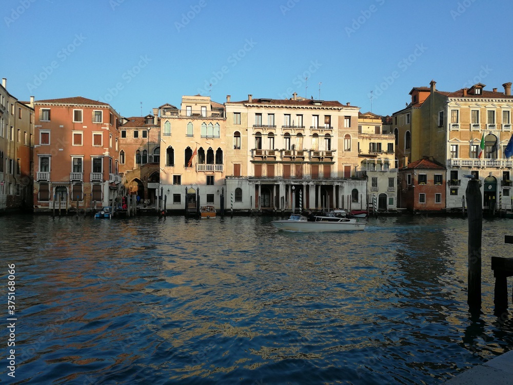 View of Venice canal and buildings on the water in the famous city of Venice Italy Europe with blue sky backdrop 