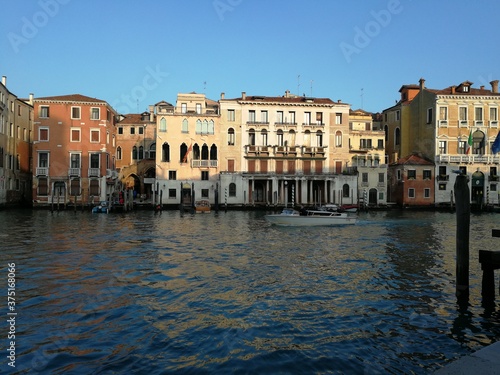 View of Venice canal and buildings on the water in the famous city of Venice Italy Europe with blue sky backdrop 
