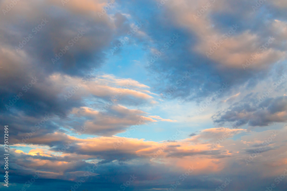 Bright cumulus clouds against the blue sky. Sunset sky Natural background.