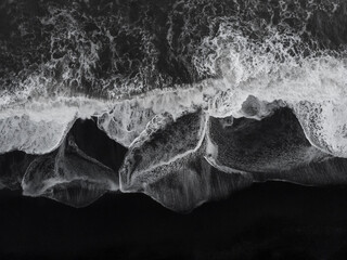 Abstract nature background. Aerial drone view of Reynisfjara Black Sand Beach and ocean waves in South Iceland near Vik village