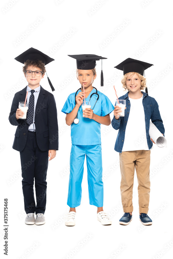 children in graduation caps dressed in costumes of different professions holding glasses with milk isolated on white children in graduation caps dressed in costumes of different professions holding glasses with milk isolated on white
