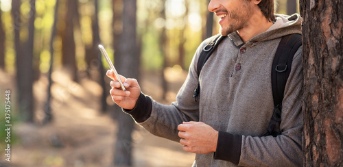 Cropped of man using smartphone at forest