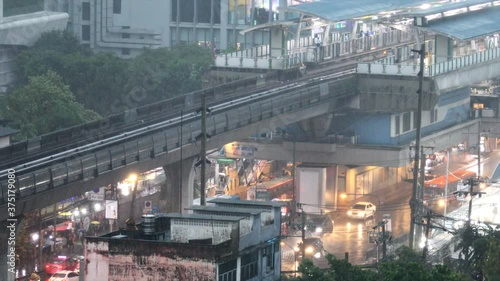 On Nut, Bangkok - 20 August 2020: Traffic drives through Sukhumvit Road. Cars, skytrains and people walking on Sukhumvit On Nut Road on a rainy day, Bangkok. photo