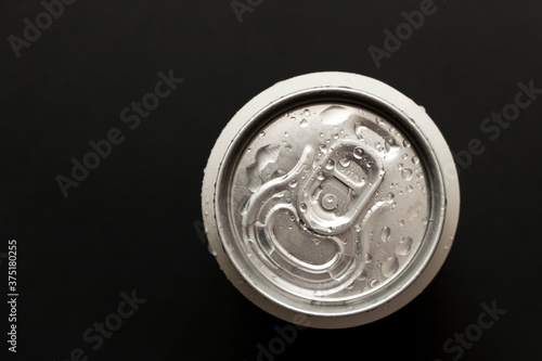 A chilled can of beer on a dark background. The view from the top. Close up.