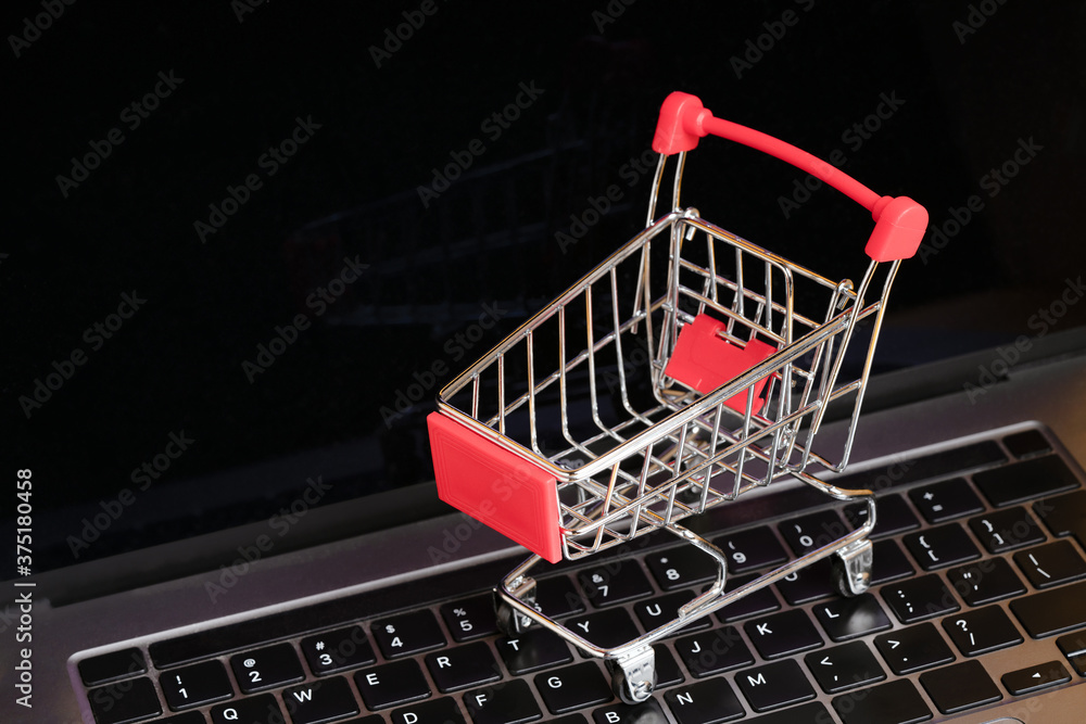 Shopping cart on laptop computer keyboard. Online shopping, internet shop, e-commerce concept
