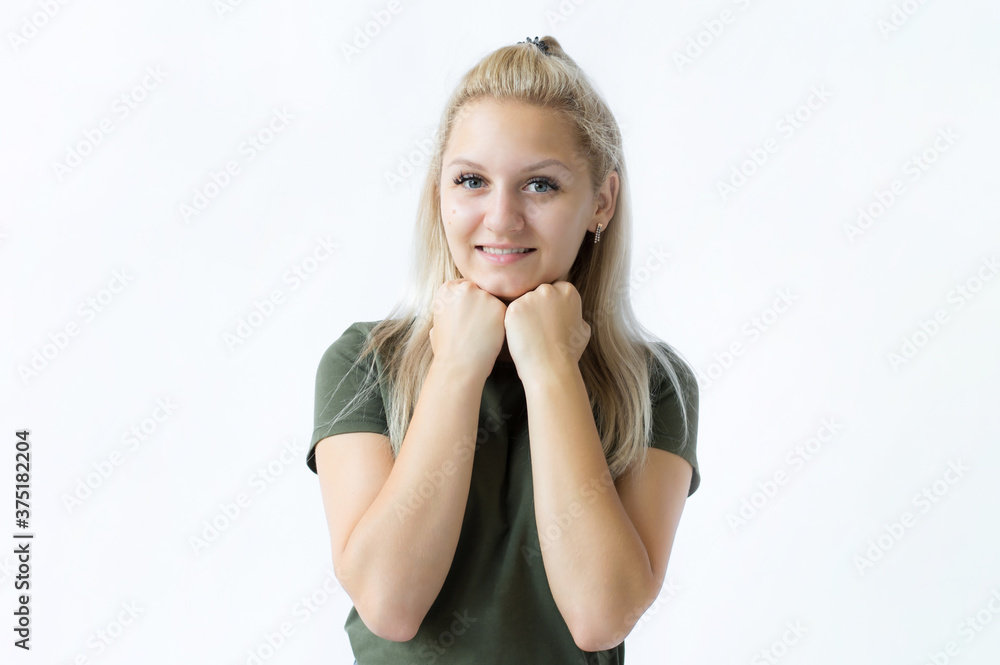 Portrait of a girl, she is happy, she clenched her hands into fists and brought them to her cheeks. Photo on white background Portrait of a girl, she is happy, she clenched her hands into fists and brought them to her cheeks. Photo on white background