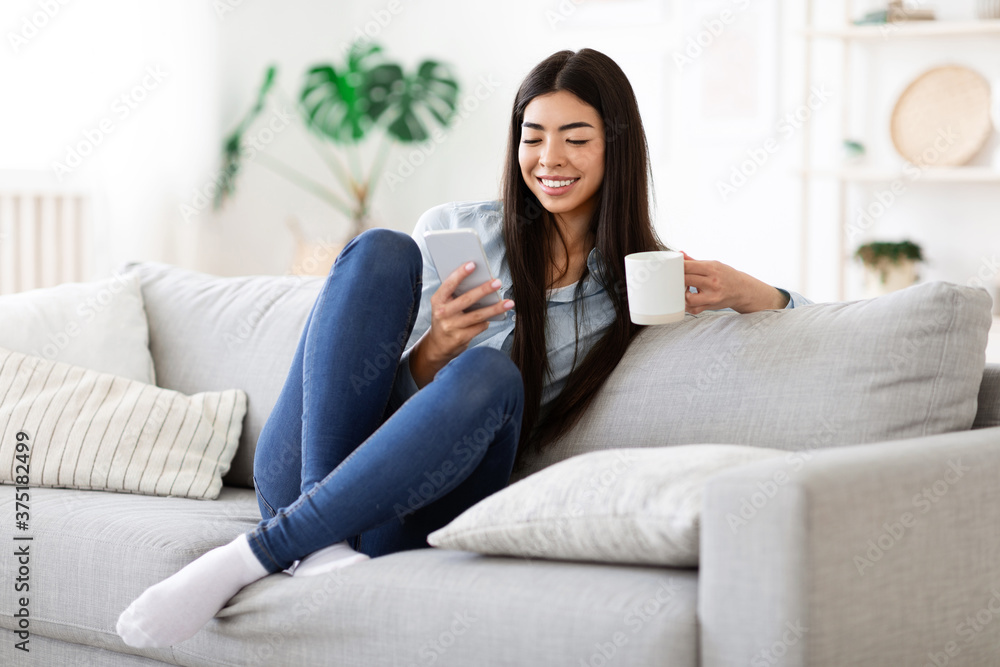 Weekend Relax. Happy Asian Girl Using Smartphone And Having Morning Coffee Weekend Relax. Happy Asian Girl Using Smartphone And Having Morning Coffee