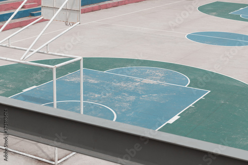 cement basketball and soccer court, painted in different colors alone, photo with daylight