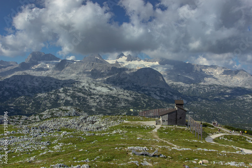 Scenic summer landscape of the Austrian Alps from Krippenstein.View of the Dachstein Mountains range in Obertraun, Austria, Europe.Small wooden church in the mountains.Travel healthy lifestyle scene