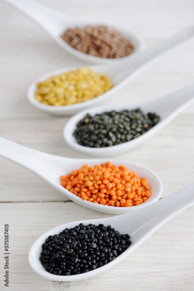 Food: Different sorts of Lentils in White Spoons Food: Different sorts of Lentils in White Spoons
