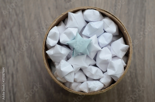 A full lucky origami stars in cardboard jar, box