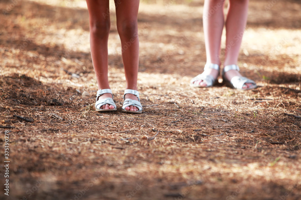Two young girls lower legs standing side by side Two young girls lower legs standing side by side
