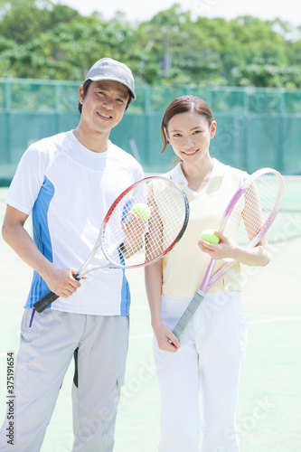 テニスコートのカップル © Paylessimages