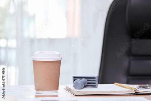 Hot coffee cup placing on manager desk together with stamp  book and document
