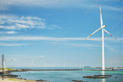 Wind turbines lined up in the blue sky and sea. Jeju Island. photo