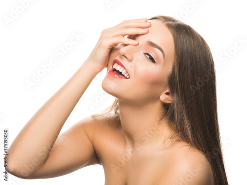 Young attractive model smiling at camera and covering one eye with hand isolated on white.