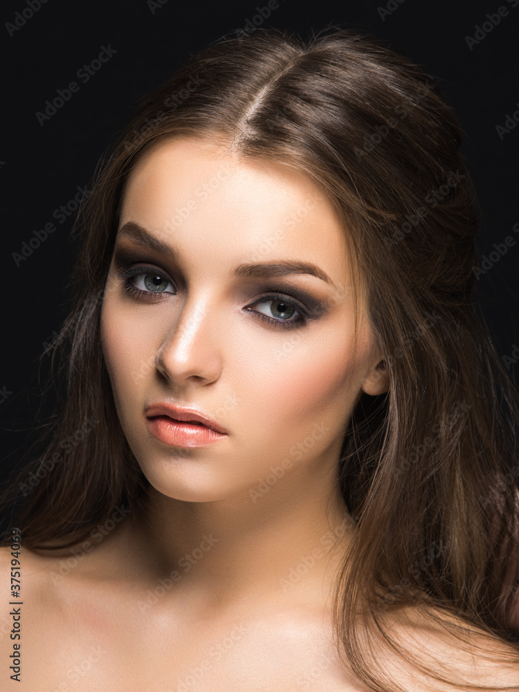 Young pretty female model with sophisticated makeup looking at camera isolated on black. Young pretty female model with sophisticated makeup looking at camera isolated on black.