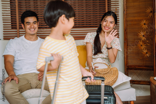 Son waving hand to say goodbye to family before study Abroad. photo