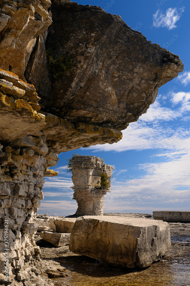 Dolomite above softer limestone in seastacks on shore of Flowerpot Island Canada